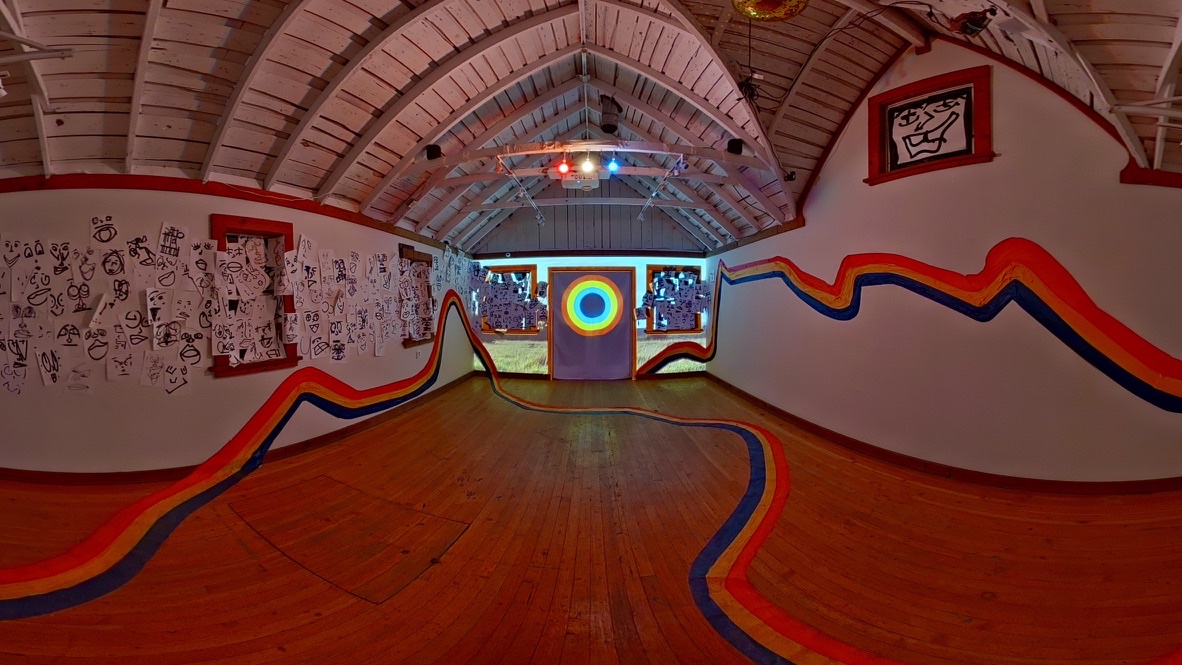 A view of the inside of a gallery with the lines and projections on the screen from the art piece EXPECTANT